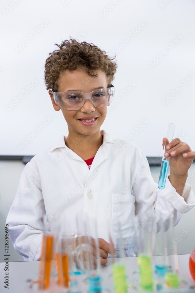 Elementary of boy holding test tube with liquid at laboratory Elementary of boy holding test tube with liquid at laboratory
