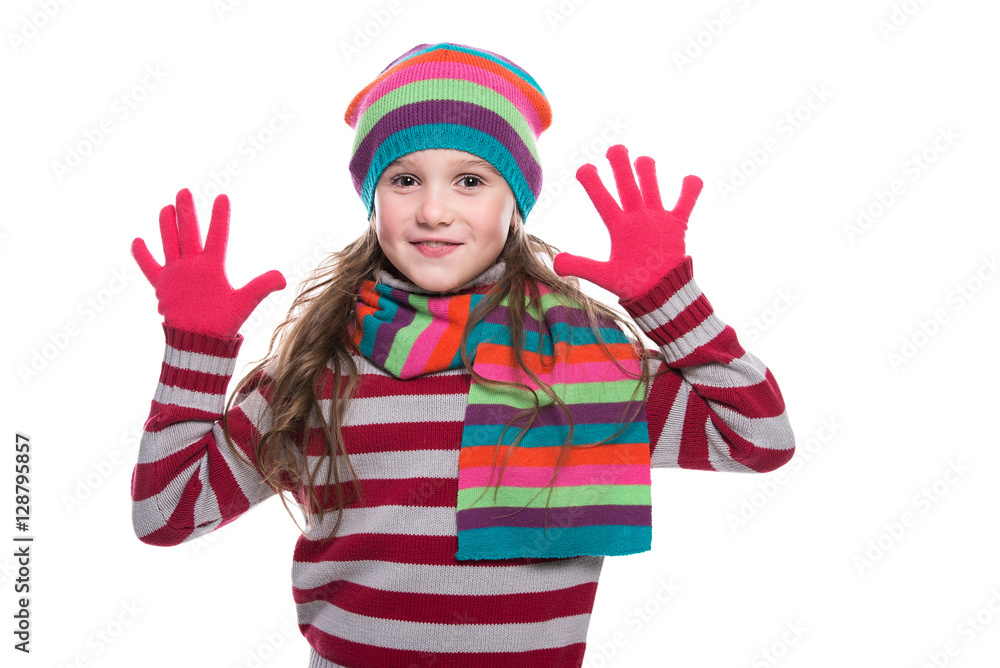 Smiling pretty little girl wearing colorful knitted scarf, hat and gloves isolated on white background. Winter clothes. Smiling pretty little girl wearing colorful knitted scarf, hat and gloves isolated on white background. Winter clothes.