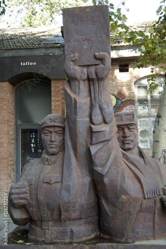 Statue of two men holding up a plaque in Beijing. photo