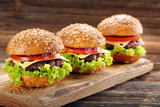 Hamburger with beef meat and fresh vegetables on wooden backgrou