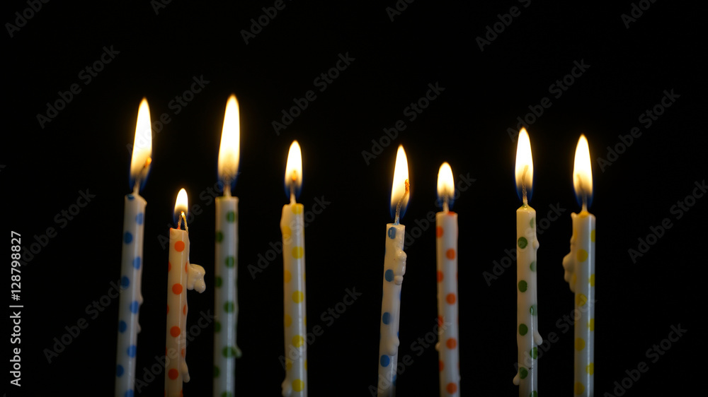 colorful burning candles set on black background colorful burning candles set on black background