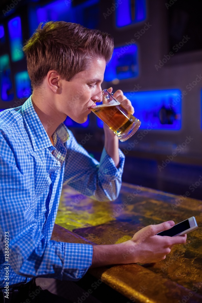 Man drinking beer at bar counter Man drinking beer at bar counter