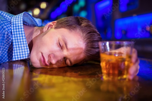 Foto Drunk man lying on bar counter