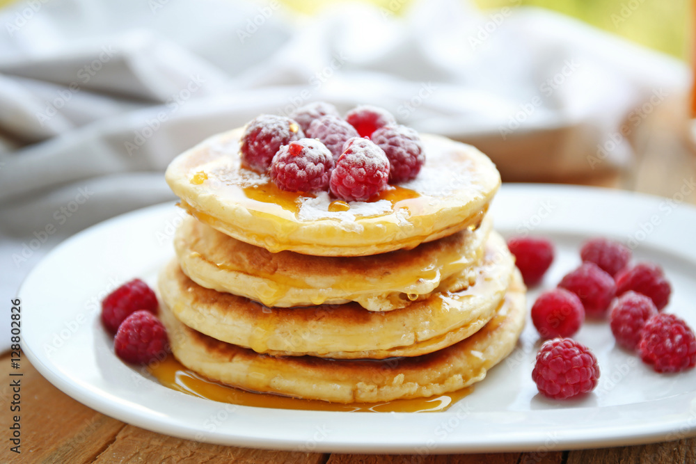 Stack of fresh pancakes with berries on white plate closeup Stack of fresh pancakes with berries on white plate closeup