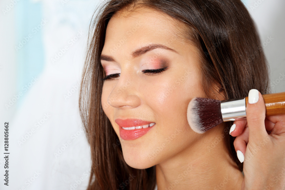 Wedding preparation. Professional makeup artist applying blush to bride Wedding preparation. Professional makeup artist applying blush to bride