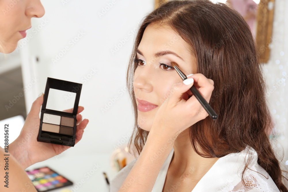 Wedding preparation. Professional makeup artist applying eye shadow to bride