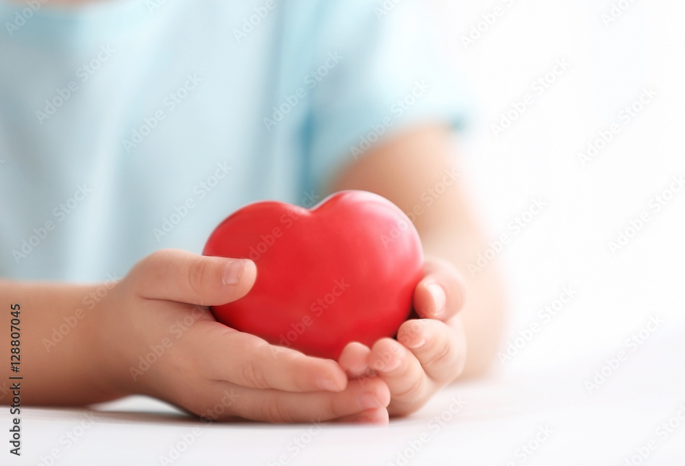 Little girl holding heart in her hands