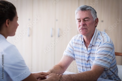 Female doctor consoling senior man