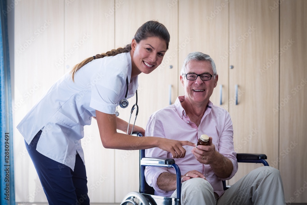 Obraz premium Portrait of female doctor giving medicine to senior man