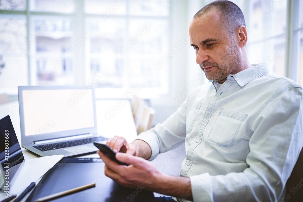 Businessman using mobile phone at desk Businessman using mobile phone at desk