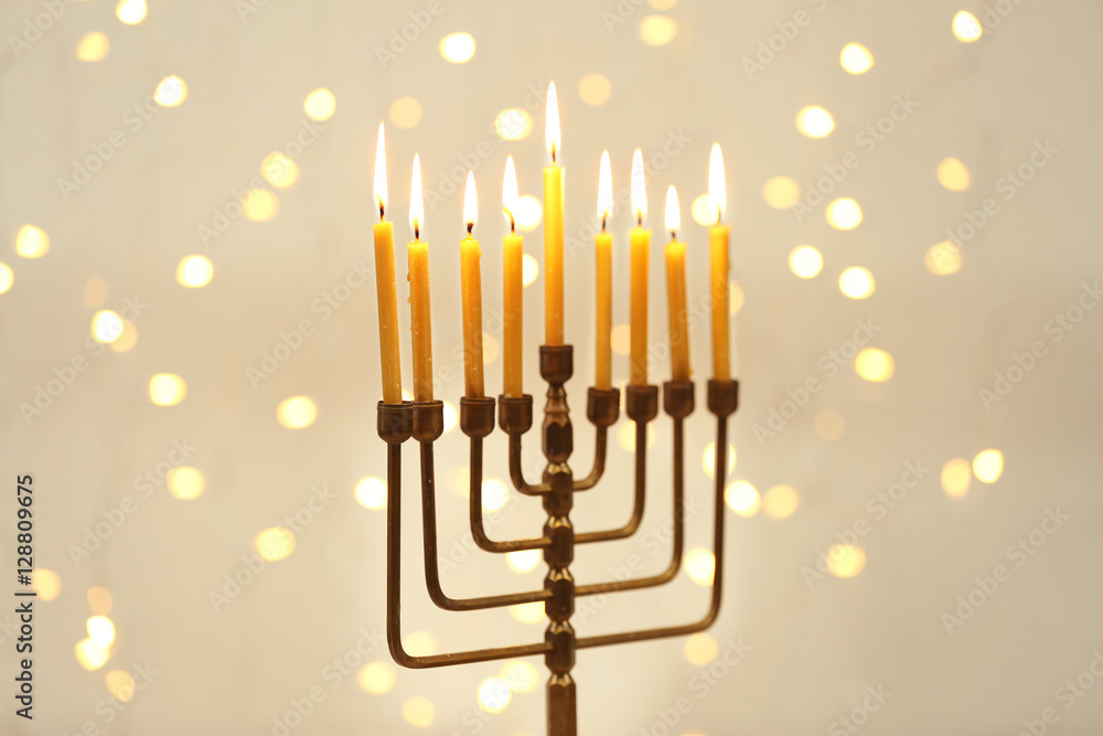 Fototapeta premium Menorah with candles for Hanukkah against defocused lights