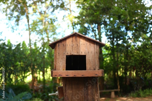 A wooden bird house with green background