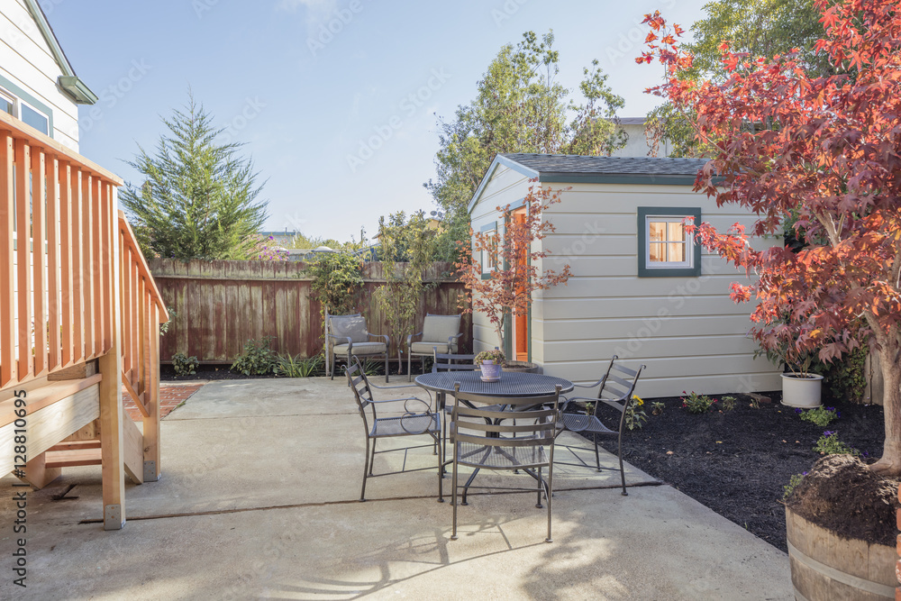 Fototapeta Yard with garden and shed and seating arrangement.
