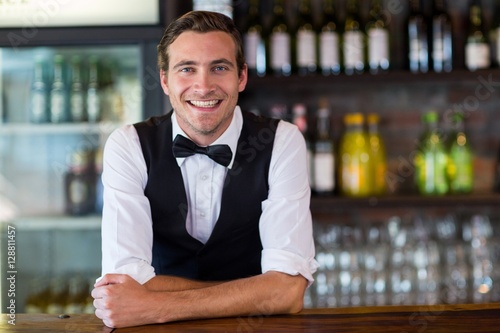 Portrait of bartender leaning on bar counter photo