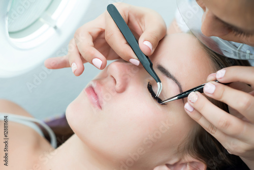 Eyelash Extension Procedure.  Woman Eye with Long Eyelashes.