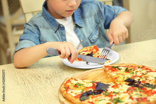 Boy eating pizza in restaurant