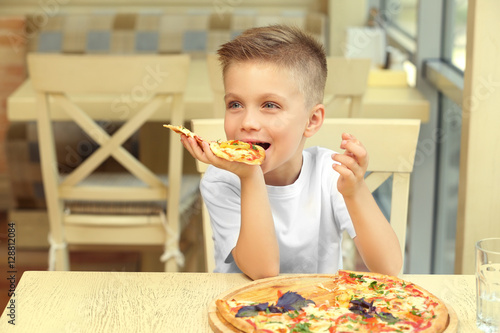 Cute boy eating pizza in re...