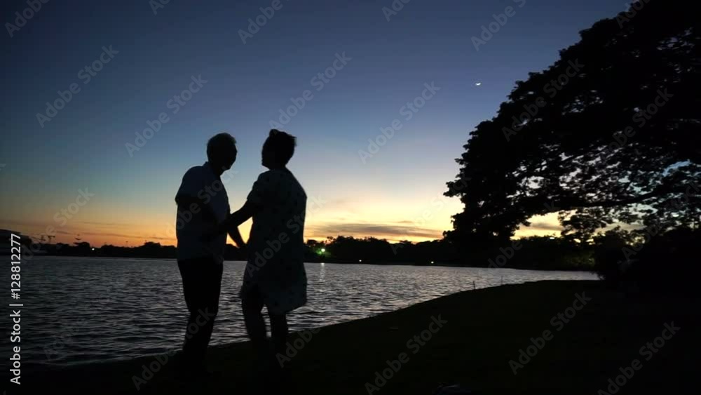 Mature Asian senior couple celebrating anniversary at lake side, morning moon and sunrise Mature Asian senior couple celebrating anniversary at lake side, morning moon and sunrise