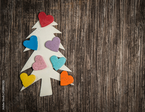 Christmas tree made of paper and hearts on wooden background