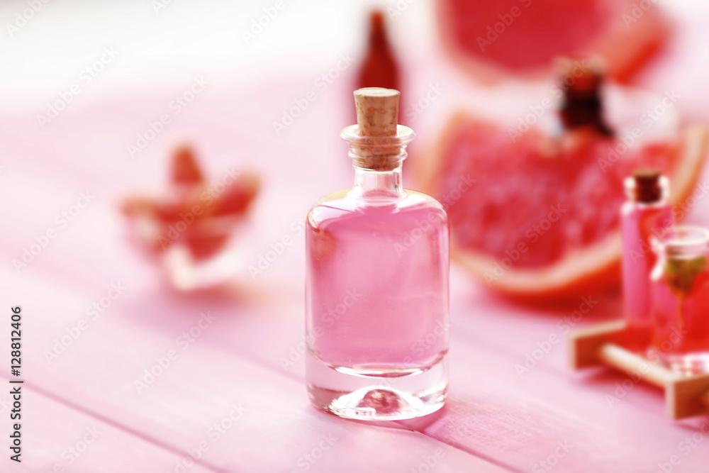 Bottle with essential oil on pink wooden table Bottle with essential oil on pink wooden table
