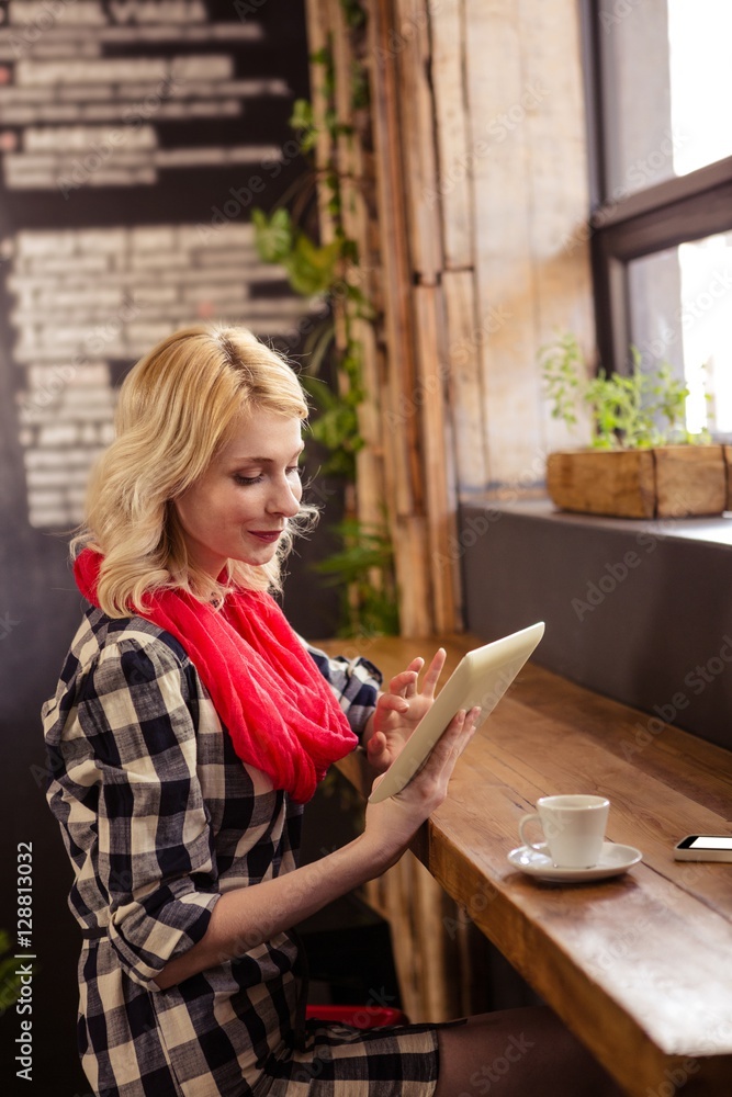 Young woman using digital tablet in cafeteria Young woman using digital tablet in cafeteria