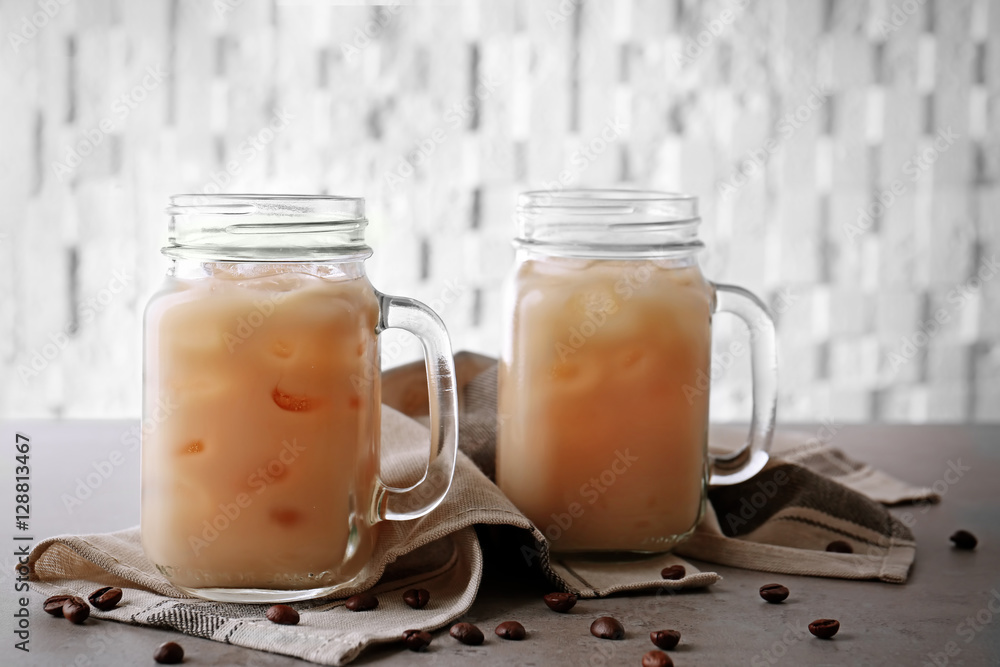 Iced coffee with milk in jars on napkin Iced coffee with milk in jars on napkin