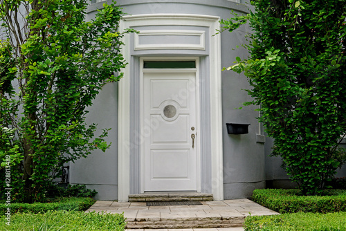 white front door framed by trees