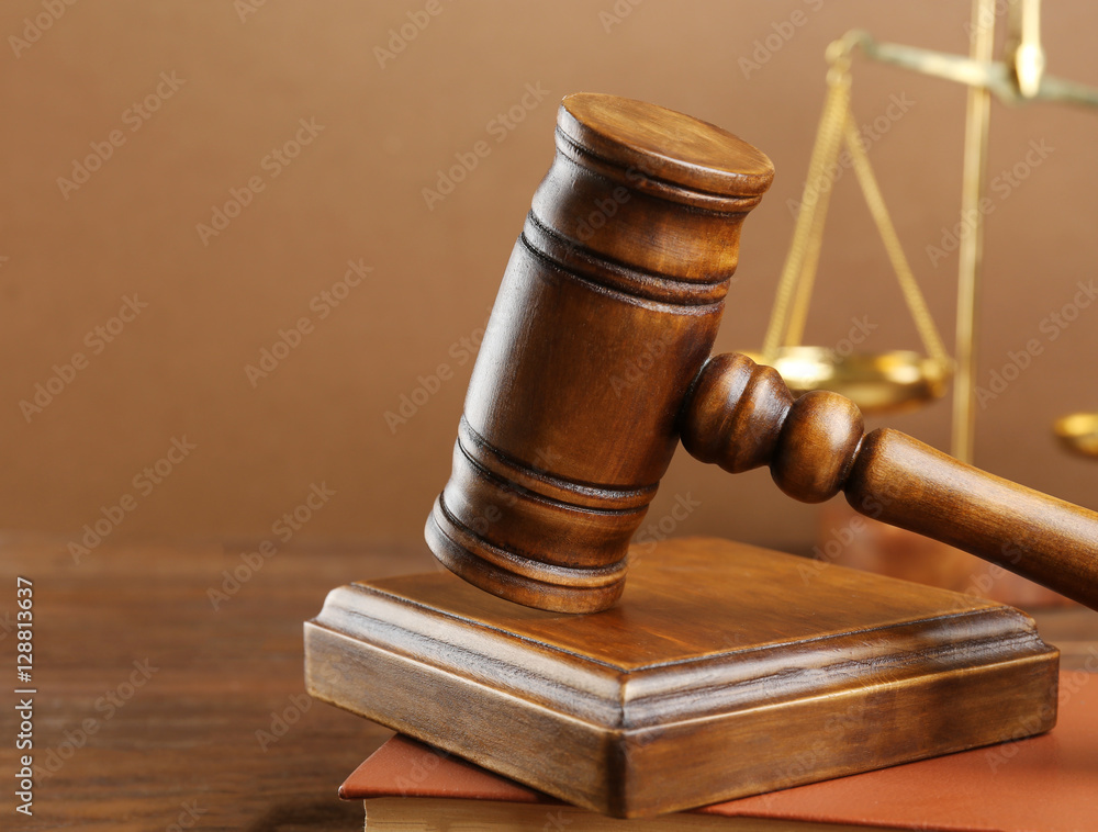 Judge's gavel and scales on brown background Judge's gavel and scales on brown background