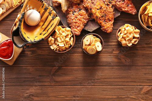 Canvas Print Baseball glove, ball and tasty snacks on wooden table