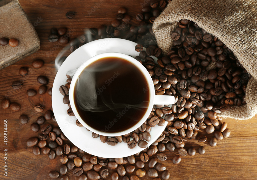 Cup of fresh coffee and sack with beans on wooden background, top view Cup of fresh coffee and sack with beans on wooden background, top view
