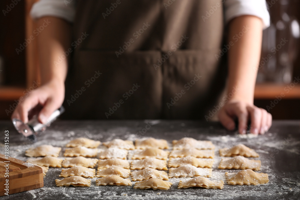 Woman making ravioli on table