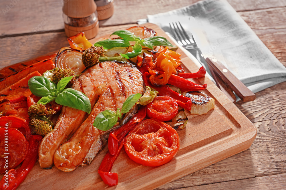 Grilled vegetables with slice of red fish on wooden cutting board Grilled vegetables with slice of red fish on wooden cutting board