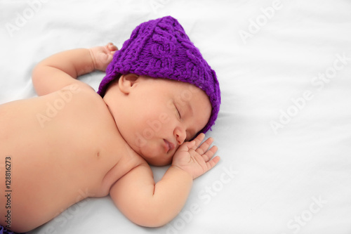 Cute baby in purple hat sle...