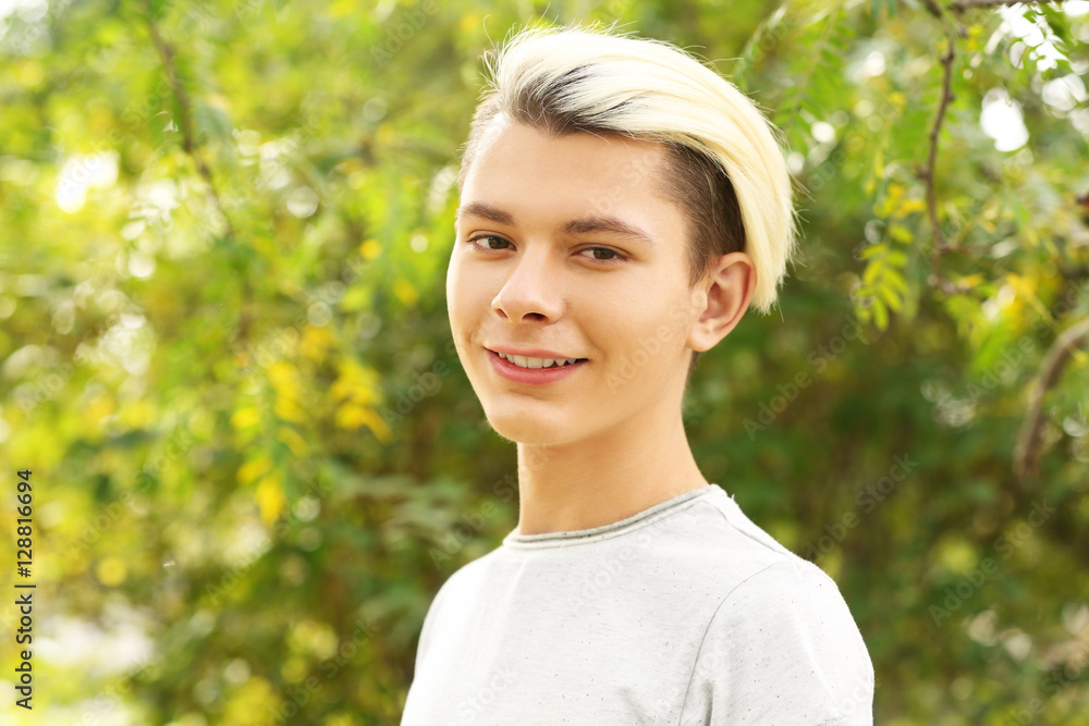 Cute teenager boy on blurred park background Cute teenager boy on blurred park background