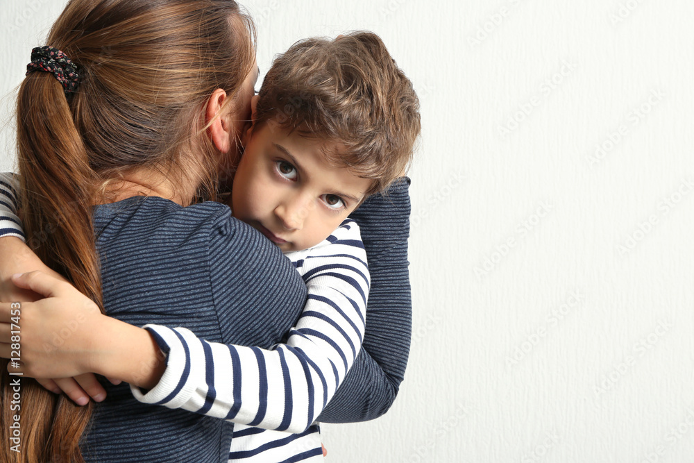 Mother hugging cute little boy, on light background Mother hugging cute little boy, on light background