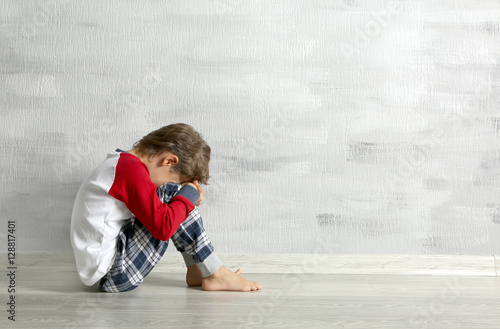 Sad little boy sitting on f...