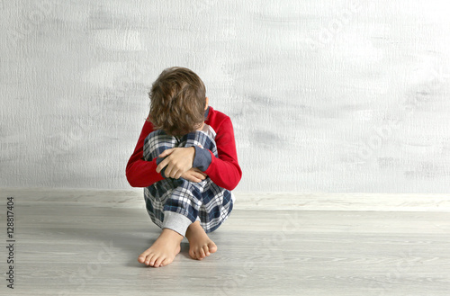 Sad little boy sitting on f...