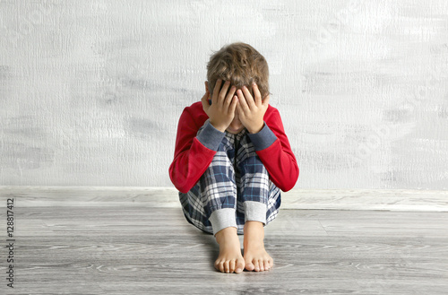 Crying little boy on floor ...