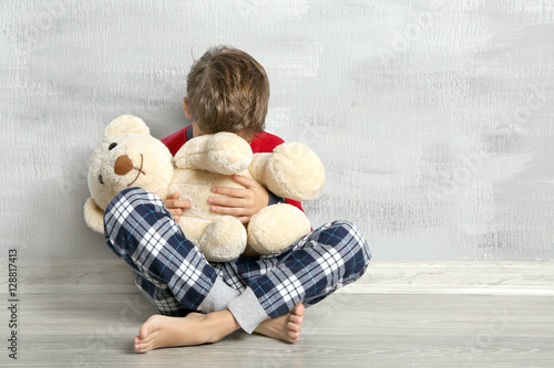 Sad little boy with teddy b...