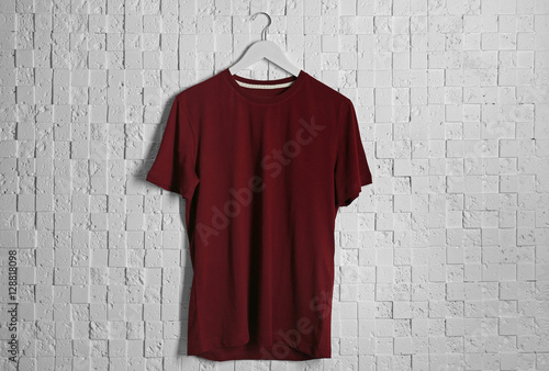 Blank maroon t-shirt against light textured background