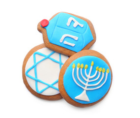 Tasty glazed cookies for Hanukkah, on white background