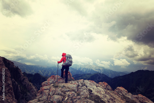 successful woman backpacker enjoy the view on mountain peak