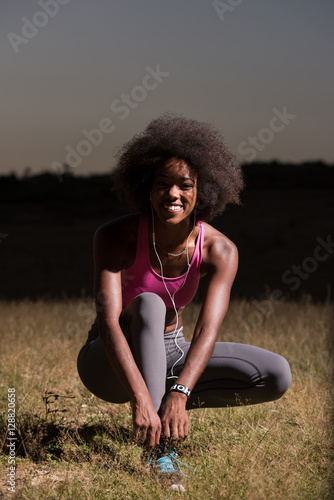 black woman runner tightening shoe lace © .shock