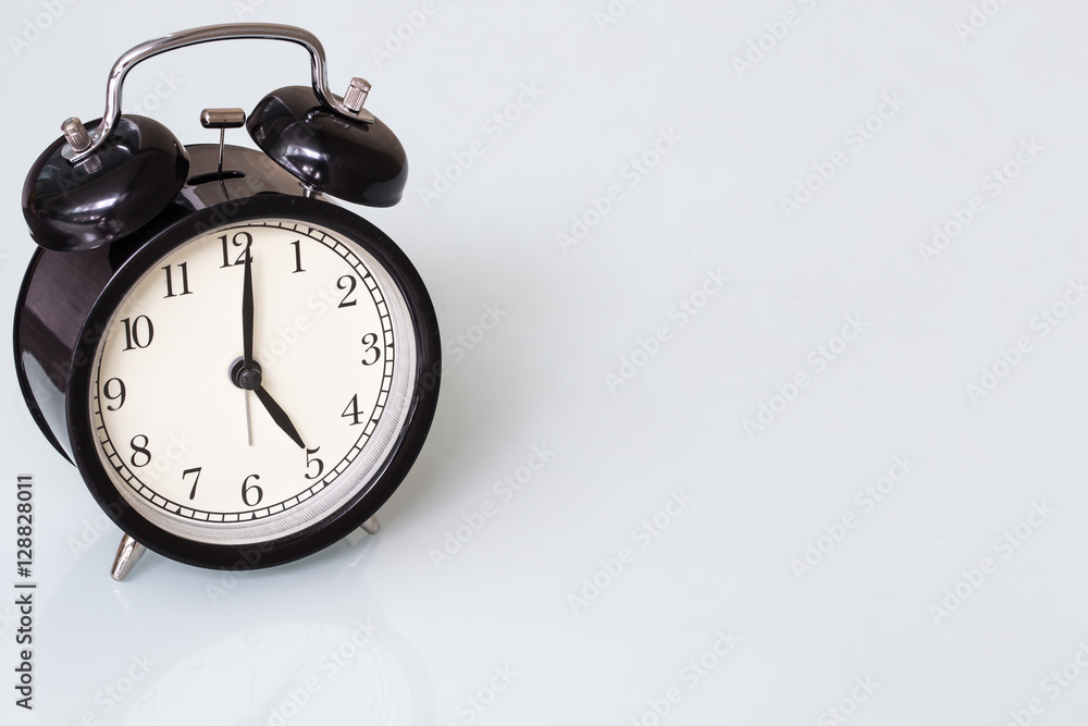 retro style black bell clock time at 5 o'clock on white background with space for text. retro style black bell clock time at 5 o'clock on white background with space for text.