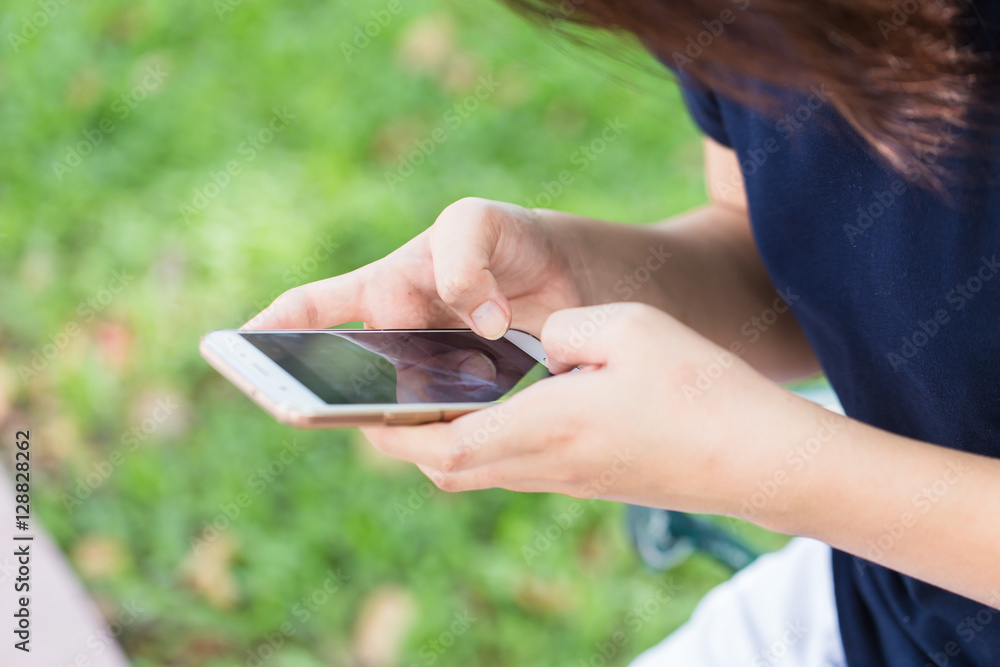 Φωτογραφία teen phone chat, Asian girl black short hair using or play with her touch screen smartphone in the park
