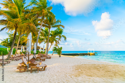 Beach chairs with umbrella at Maldives island, white sandy beach
