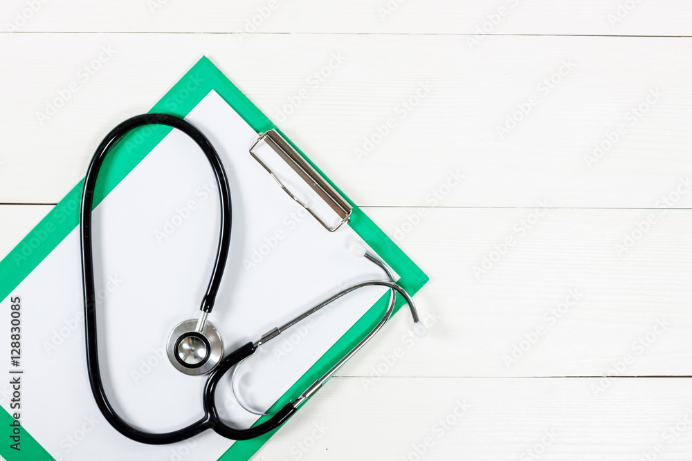Medical clipboard and stethoscope on white wooden table backgrou Medical clipboard and stethoscope on white wooden table backgrou