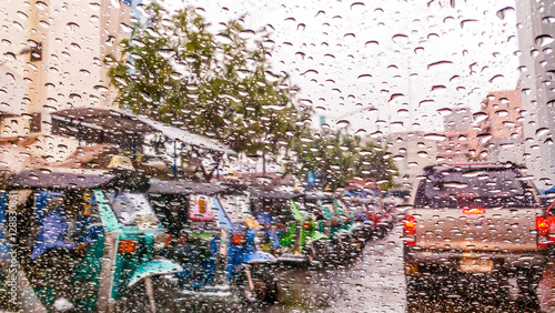 Canvas Print Water droplets on a car window while running on the road in the rain