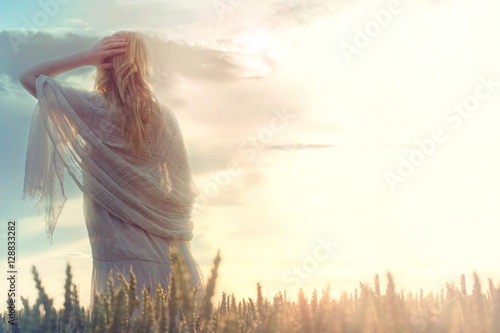 dreamy woman looks at infinity as the sun rises photo