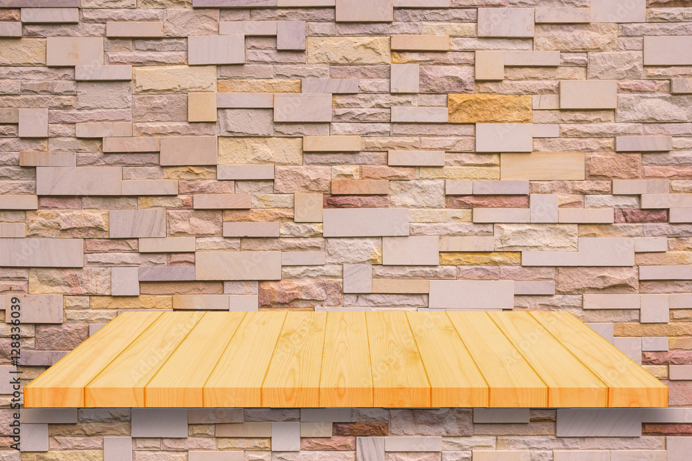 Fototapeta premium Wooden shelf on brick wall background.
